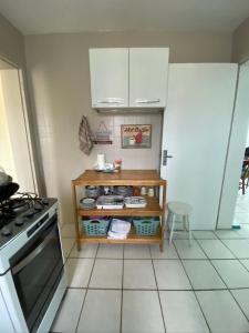 a kitchen with a stove and a shelf with dishes at Apt com vista para o mar e churrasqueira in Guaratuba