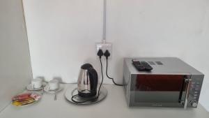 a microwave and a coffee maker and a coffee pot at Epic Den Lodge in Phuthaditjhaba