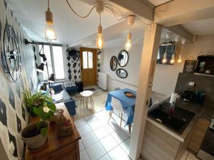 a kitchen and living room with a table and chairs at La courtine Etretat maison de pêcheur 2 mn de la mer in Étretat