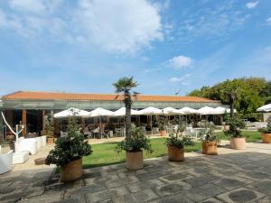 un patio con macetas y sombrillas blancas en Aguda Golf Vita, en Arcozelo