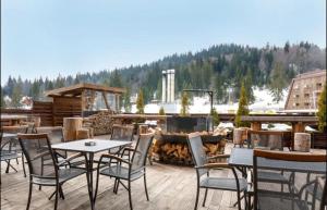 a patio with tables and chairs and a fire pit at Apartman Vučko B328 in Jahorina