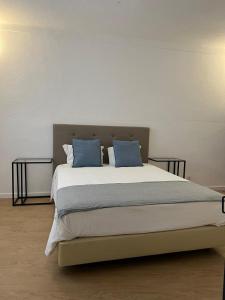 duże łóżko z niebieskimi poduszkami w sypialni w obiekcie O Conventinho w mieście Évora