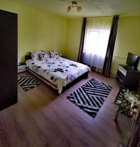 Schlafzimmer mit einem Bett und einem Fenster in der Unterkunft Casa Rusu in Mălăeşti