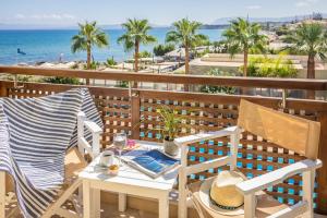a table and chairs on a balcony overlooking the ocean at Giannoulis - Santa Marina Plaza (Adults Only) in Agia Marina Nea Kydonias