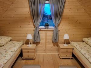 een kamer met 2 bedden en een raam bij Leśna Zagroda - Dominikowo - Tężnia, sauna, balia in Dominikowo