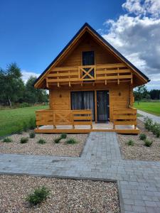 a log cabin with a bench in front of it at Leśna Zagroda - Dominikowo - Tężnia, sauna, balia in Dominikowo