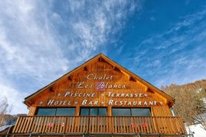 a sign on the side of a wooden building at Chalet Hôtel Les Blancs in Pra-Loup