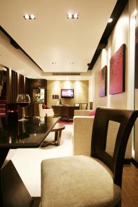 a living room with a couch and a table at Grand Inn Hotel in Bangkok