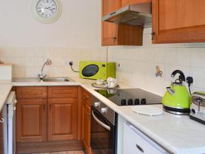a kitchen with a sink and a green microwave at Sleepy Fox Cottage in Levisham