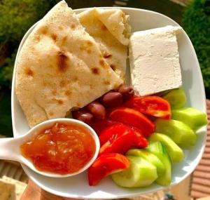 un plato de comida con verduras y queso y una cuchara en Kenzy guest house, en El Cairo