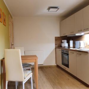 eine kleine Küche mit einem Holztisch sowie einem Tisch und Stühlen in der Unterkunft Ferienhaus Willkommen in Bad Schandau