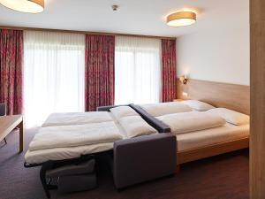 ein Schlafzimmer mit einem großen Bett vor einem Fenster in der Unterkunft Hoftaverne Ziegelböck in Vorchdorf