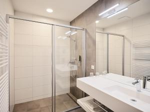 a bathroom with a sink and a glass shower at Hoftaverne Ziegelböck in Vorchdorf