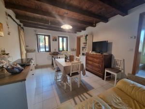eine Küche und ein Wohnzimmer mit einem Tisch, einer Küche und einem Esszimmer in der Unterkunft dal vecio Carli in SantʼAmbrogio di Valpolicella