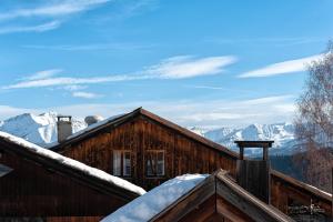 une cabane en rondins avec de la neige sur le toit dans l'établissement Chalet Hôtel Les Blancs, à Pra-Loup