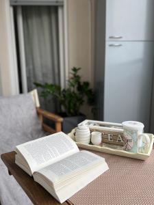 a table topped with an open book and a tray with a book at Oscar in Podgorica