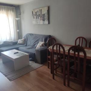 sala de estar con sofá, mesa y sillas en Piso Inma, en Covaleda
