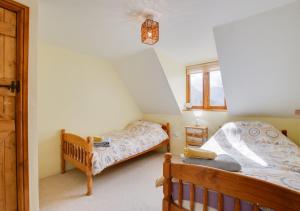 a bedroom with two twin beds and a window at Tyn y Maes in Bethesda