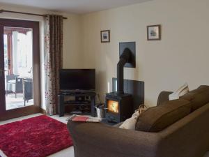 a living room with a couch and a wood stove at Bluebell Barn in Ravenstonedale