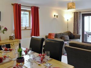 una sala de estar con una mesa con copas de vino. en Bluebell Barn en Ravenstonedale