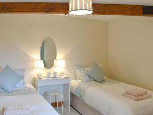 a small room with two beds and a mirror at Bluebell Barn in Ravenstonedale