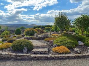 a garden with a stone path and bushes at Bluebell Barn in Ravenstonedale