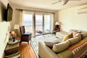 a living room with a couch and a large window at Bayside Beauty in Truro