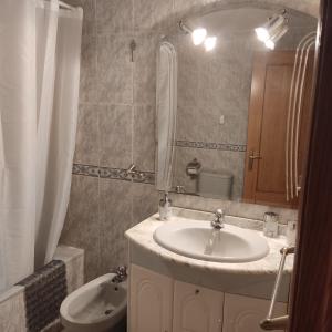 W łazience znajduje się umywalka, toaleta i lustro. w obiekcie Piso Inma w mieście Covaleda