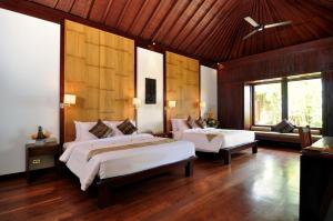 a bedroom with two beds in a room at Anginsepoi in Canggu