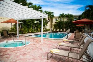 a swimming pool with chairs and a table and umbrella at Inn at the Beach-Venice FLORIDA in Venice