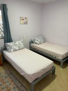 2 camas individuales en una habitación con alfombra en Casa Claddagh en Sax
