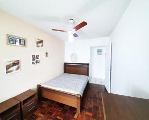 a bedroom with a bed and a ceiling fan at Apt com vista para o mar e churrasqueira in Guaratuba