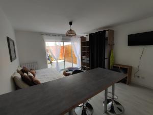 sala de estar con mesa y sofá en Studio meublé équipé avec terrasse privative, en Thionville