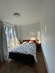 um quarto com uma cama e uma grande janela em LIKEHOME - Grande maison conviviale pour groupe proche PARIS em Villiers-le-Bel