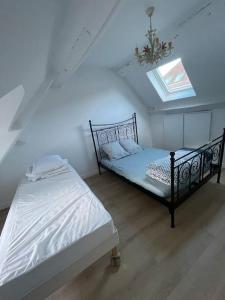 um quarto com 2 camas e uma clarabóia em LIKEHOME - Grande maison conviviale pour groupe proche PARIS em Villiers-le-Bel