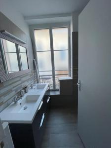 uma casa de banho com 2 lavatórios e 2 janelas em LIKEHOME - Grande maison conviviale pour groupe proche PARIS em Villiers-le-Bel