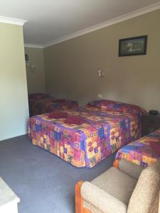 a hotel room with two beds and a couch at Wagon Wheel Motel & Units in Coonabarabran +10 photos