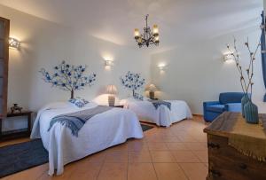 sypialnia z 2 łóżkami i niebieską kanapą w obiekcie Hacienda La Moreda Hotel Boutique & Spa w mieście Guadalajara
