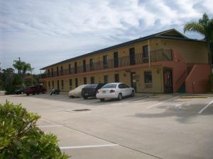 un edificio con coches estacionados en un estacionamiento en All-Suite Motel, LLC, en Edgewater