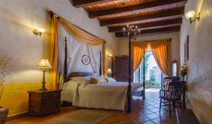 a bedroom with a bed and a table and chairs at Hacienda La Moreda Hotel Boutique & Spa in Guadalajara
