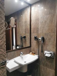 a bathroom with a sink and a mirror at Apartament 508-Aparthotel Alpin Poiana Brasov- acces la piscină gratuit in Poiana Brasov