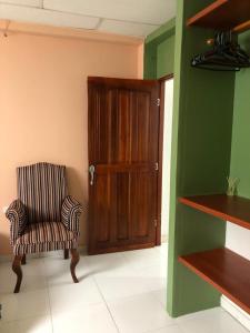 Zimmer mit einem Stuhl und einer Holztür in der Unterkunft Habitacion en Cartagena in Cartagena de Indias