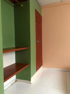 um quarto com uma parede verde e uma porta de madeira em Habitacion en Cartagena em Cartagena de Indias
