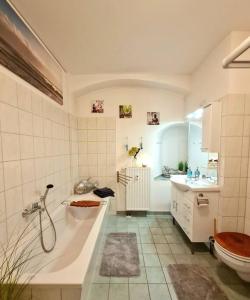 e bagno con vasca, servizi igienici e lavandino. di NEU: Großzügige Citywohnung mit XXL Dachterrasse! a Freiberg