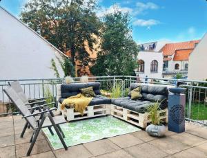 un patio con 2 divani e una sedia di NEU: Großzügige Citywohnung mit XXL Dachterrasse! a Freiberg