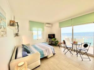 a bedroom with a bed and a view of the ocean at Exclusive Frontline Promocanyell Roses - Immo Barneda in Roses