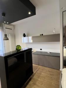a living room with a television and a kitchen at Alfea Suite in Bologna