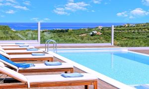 a pool with lounge chairs and a view of the ocean at Stavento Luxury Villa Private Pool in Georgioupolis