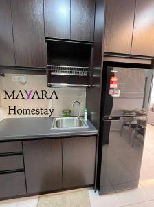 a kitchen with a sink and a microwave at MAYARA Homestay @ Residensi Lili in Nilai