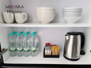 a shelf with bottles and bowls and a coffee pot at MAYARA Homestay @ Residensi Lili in Nilai